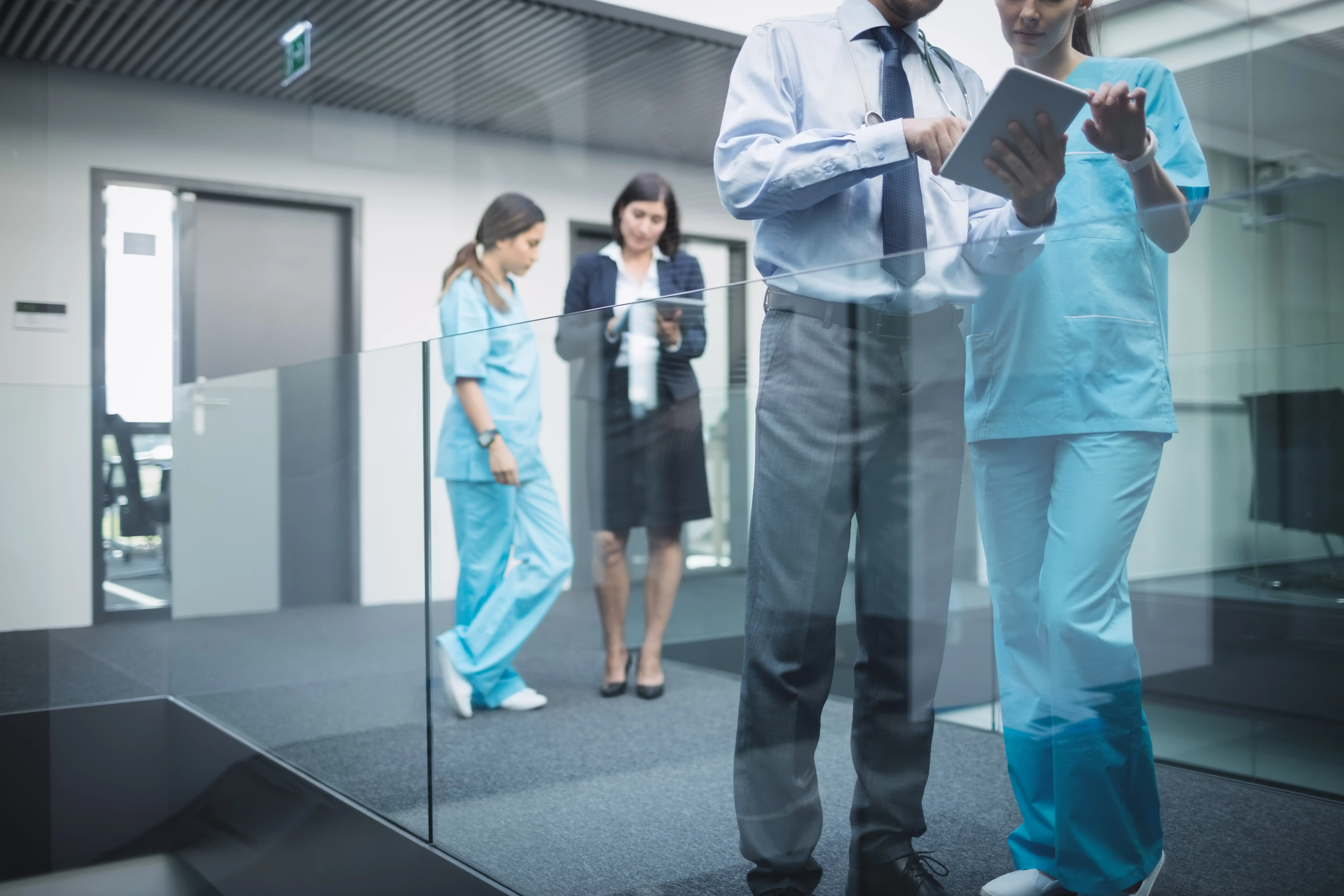 A group of doctors and nurses standing together in a well-lit office, engaged in discussion and collaboration.