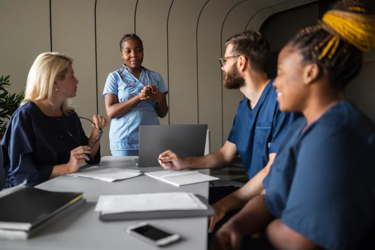 A group of nurses engaged in conversation, sharing insights and discussing patient care in a hospital setting.