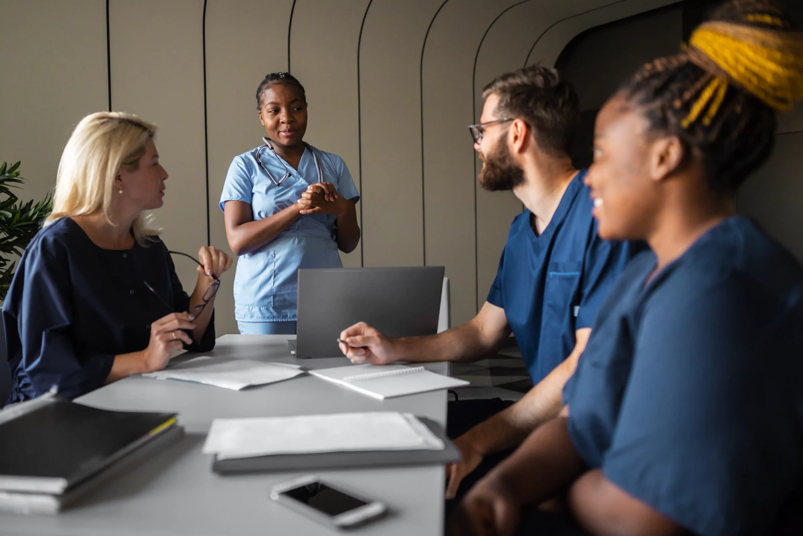 A group of nurses engaged in conversation, sharing insights and discussing patient care in a hospital setting.